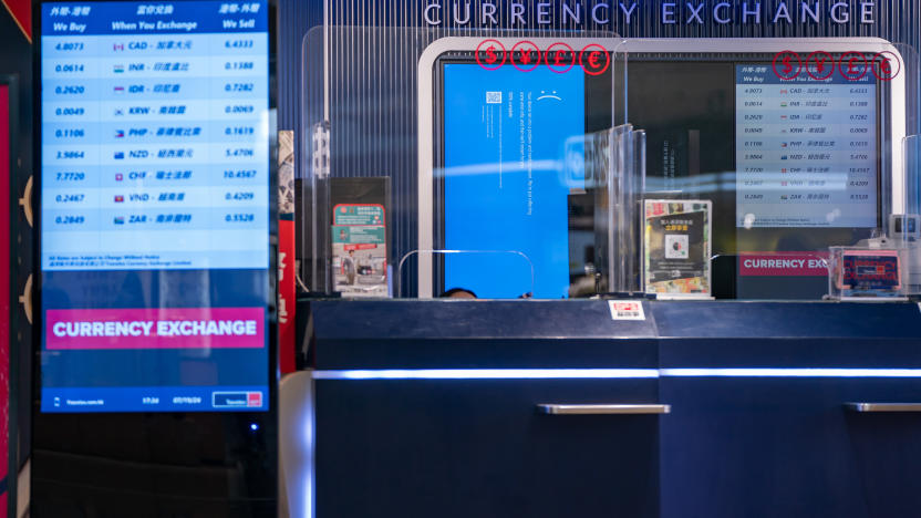 HONG KONG, CHINA - JULY 19: A error blue screen is displayed at a currency exchange store at the Hong Kong International Airport on July 19, 2024 in Hong Kong, China. A significant Microsoft outage impacted users globally, leading to widespread disruptions, including cancelled flights and disruptions at retailers globally. Airlines like American Airlines and Southwest Airlines reported difficulties with their systems, which rely on Microsoft services for operations. The outage affected check-in processes and other essential functions, causing frustration among travellers and lines to back up at many affected airports worldwide. (Photo by Anthony Kwan/Getty Images)