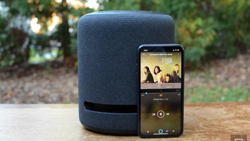 Amazon Music on a smartphone next to an Echo speaker.