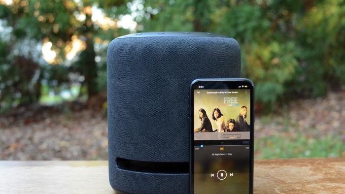 Amazon Music on a smartphone next to an Echo speaker.