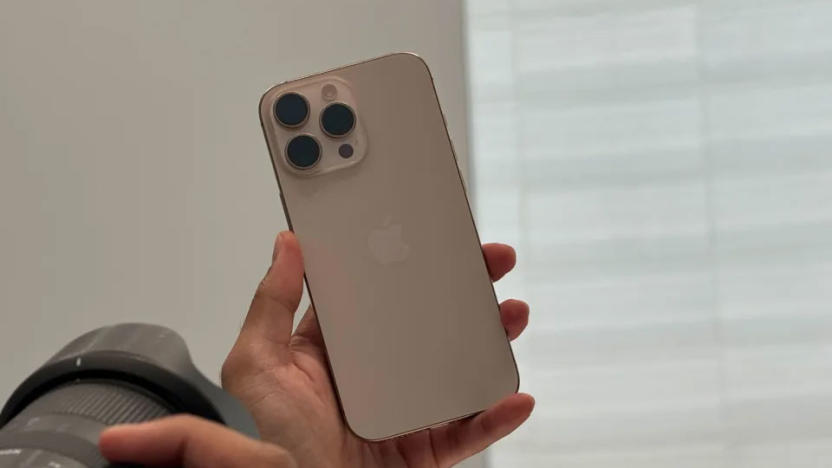 Image of the iPhone 16 Pro being held aloft while a photographer attempts to photograph it.