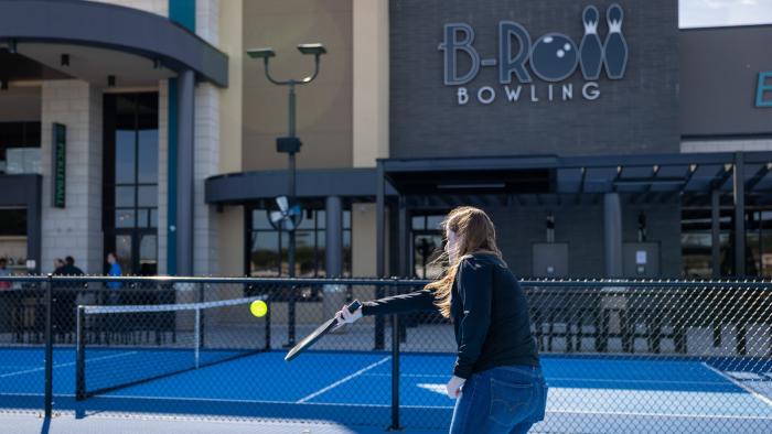 A person on a court holding a racket .