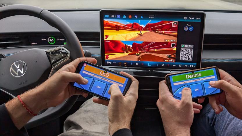 Two people use smartphones to control a game on a Volkswagen infotainment display.