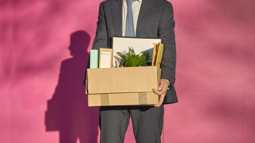 Businessman carrying box with personal belongings on sunny day