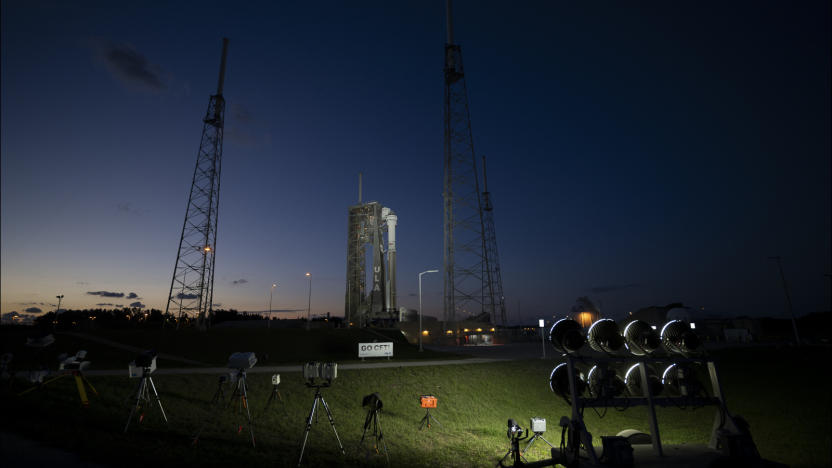 A rocket in the distance lit by spotlights in the foreground.