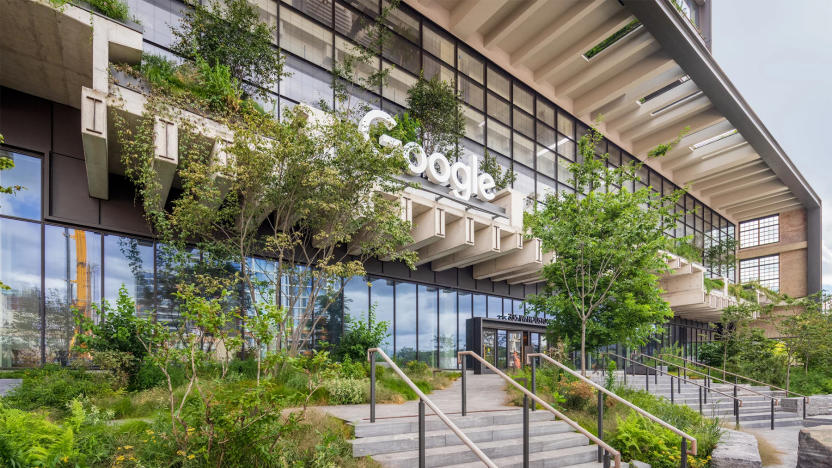 View of the front of Google's St. John’s Terminal offices. Logo on a sign over a doorway. Modern architecture. Trees and bushes.