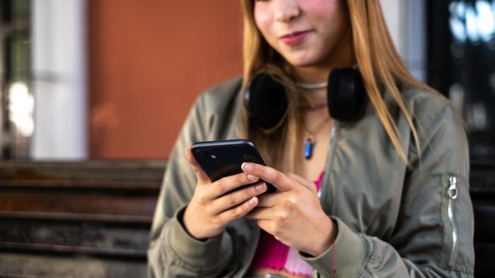 Teenager girl using the mobile phone outdoors