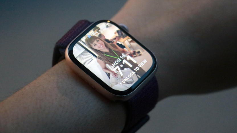 The Apple Watch Series 10 with a Photos watch face open on its home screen, worn on a wrist held in mid-air.