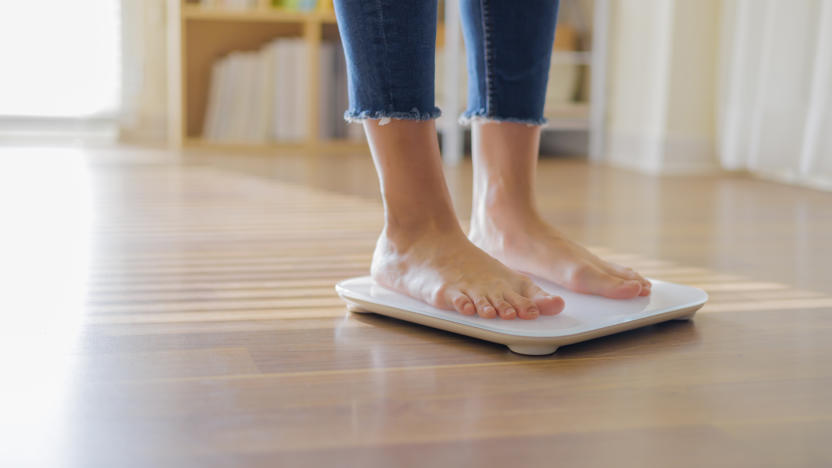 woman weighing on scale to measure her weight