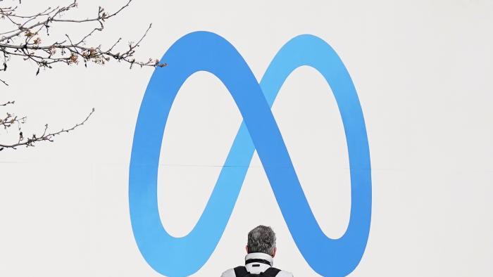 FILE - A person stands in front of a Meta sign outside of the company's headquarters in Menlo Park, Calif., March 7, 2023. (AP Photo/Jeff Chiu, File)